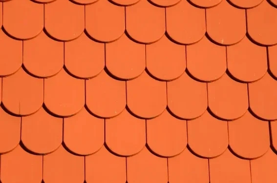 Tuiles en terre cuite de couleur orange disposées en motifs ondulés.